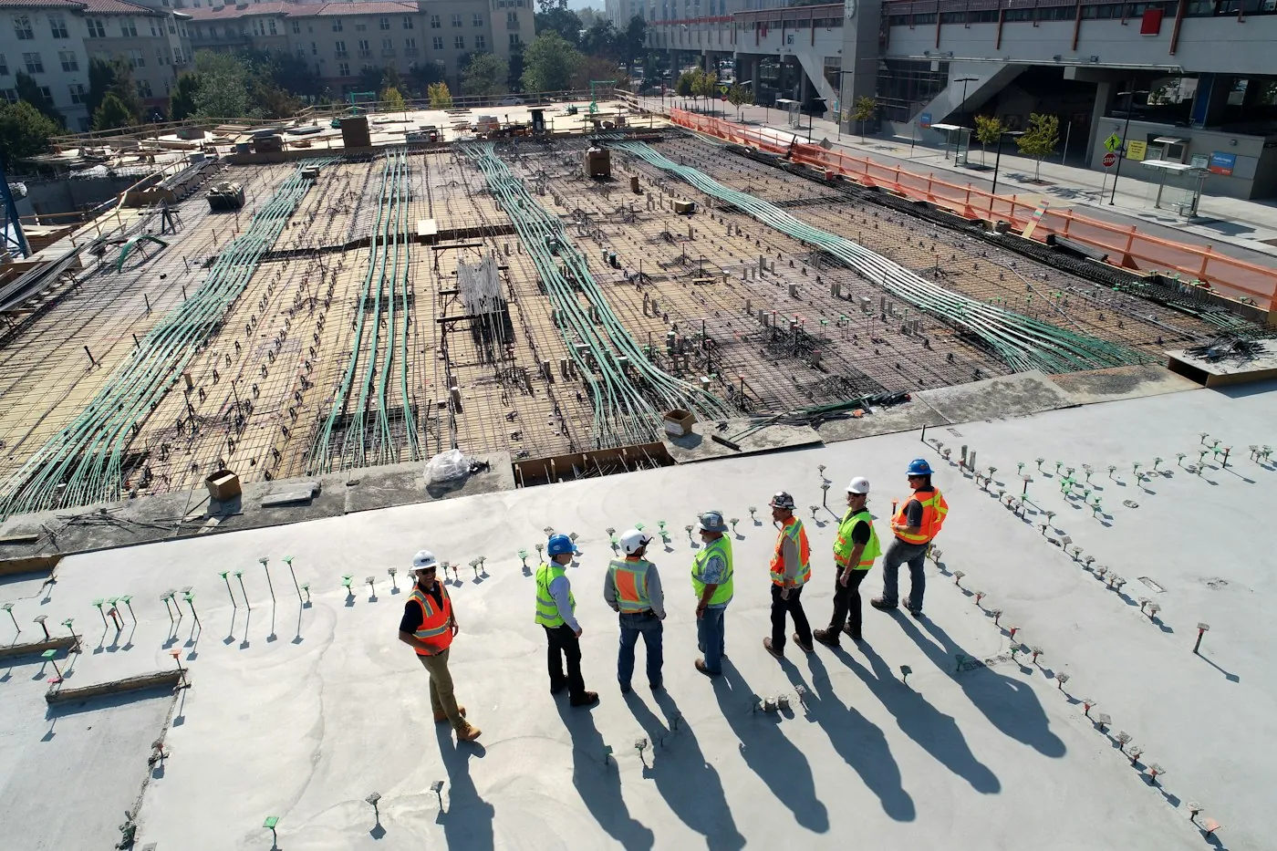 A site team standing on a finished concrete slab next to a rebar deck